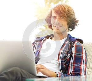 Serious guy working sitting near the desktop.