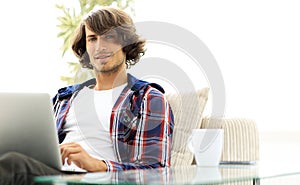 Serious guy working sitting near the desktop.