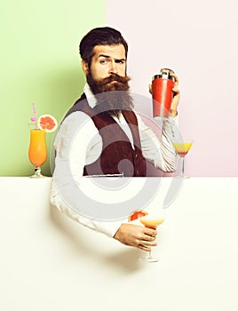 Serious handsome bearded barman on purple green studio background