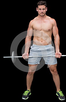 Serious handsome crossfitter lifting up barbell
