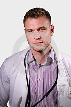 Serious handsome male doctor wearing white lab coat looking at camera