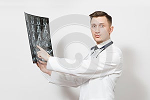 Serious handsome young doctor man holds x-ray radiographic image ct scan mri isolated on white background. Male doctor