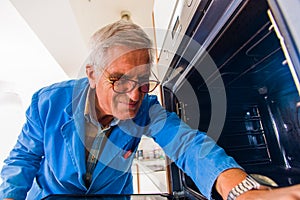 Serious handyman fixing oven