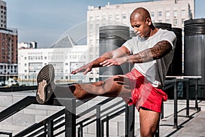 Serious hard working man developing his flexibility