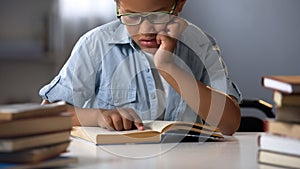 Serious hardworking pupil reading book at home, early child development, erudite