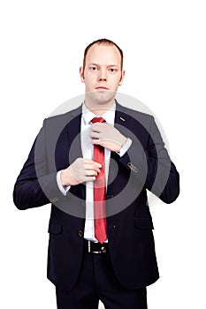 Serious head of the firm in a business suit corrects red tie on