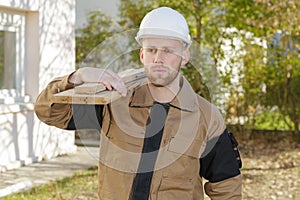 Serious home builder carrying wood