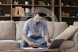 Serious homeowner man using accounting financial banking online app