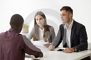 Serious hr managers listen to african applicant at job interview