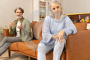 Serious husband talking to his ill-humored wife