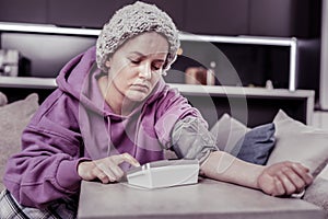 Serious ill female person using modern equipment