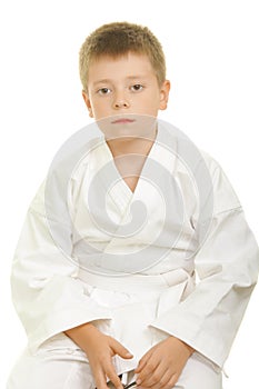Serious karate kid sitting on knees