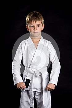 Serious kid in brand new kimono on black background