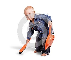 Serious kid holds scoop and broom