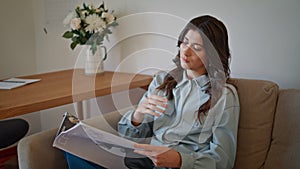Serious lady reading press flipping at interior closeup. Woman looking magazine