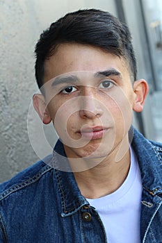 Serious Latino teen outdoors close up