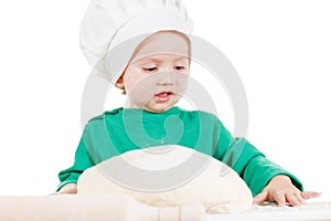 Serious little boy kneading dough for the cookies, isolated on white