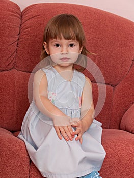 Serious little girl on the sofa