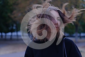 Serious look of girl with windy hair at dark street