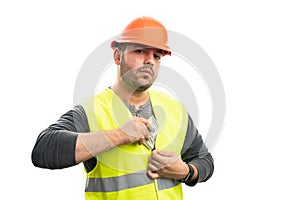 Serious male builder hiding cash money inside fluorescent vest