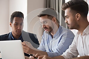 Serious male colleagues use laptop discussing business ideas