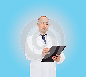 Serious male doctor with clipboard