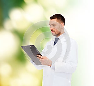 Serious male doctor with clipboard