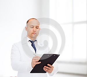 Serious male doctor with clipboard