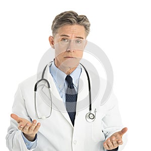 Serious Male Doctor Gesturing Against White Background