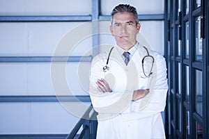 Serious male doctor standing with arms crossed