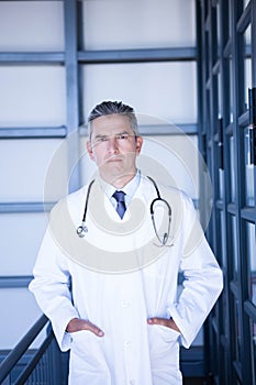 Serious male doctor standing with hands in pocket