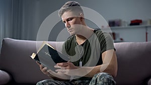 Serious male military reading bible, religion and faith, psychological therapy