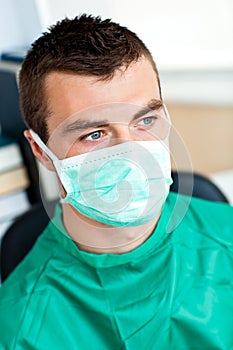 Serious male surgeon with mask and scrubs