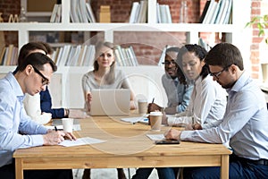 Serious male workers sign business agreement at briefing