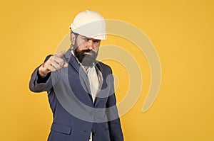 serious man with beard wear hard hat pointing finger. engineering. architecture and building. male builder wearing