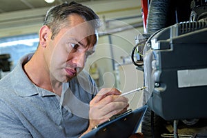 Serious man checking machinery supervison