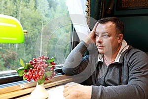 Serious man in compartment of retro train carriage