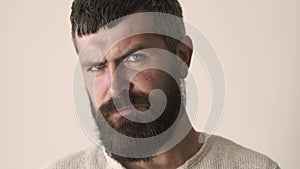 Serious man face close up. Portrait of handsome bearded young guy looking at camera.