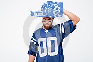 Serious man fan in blue t-shirt standing isolated