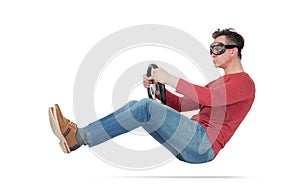 Serious man in goggles drives a car with steering wheel, isolated on white background