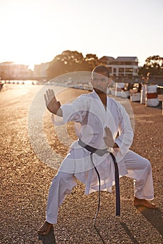 Serious man, karate and fitness with self defense in city for kata, fighting technique or style. Young male person or