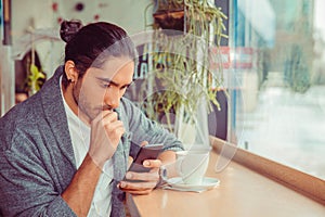 Serious man looking at phone, worried by news he received