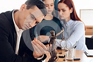 Serious man looks at wedding ring in lawyer office