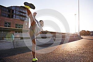 Serious man, muay thai and fitness with kick in city for self defense, fighting technique or style. Young male person