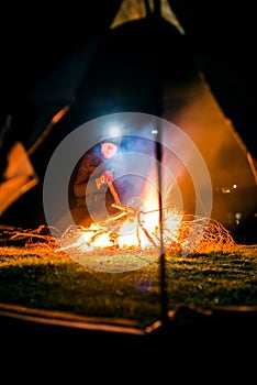 Serious man near camp fire