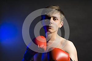 Serious man in red boxing gloves