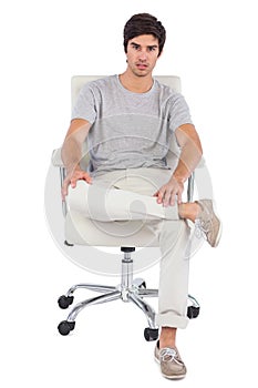 Serious man sitting on a swivel chair