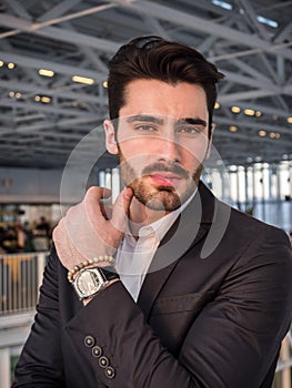 Serious man standing inside modern building