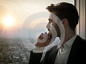 Serious man standing inside modern building