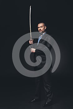 serious man in suit with japanese katana sword